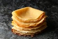 Delicious thin pancakes on black smokey background