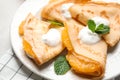 Delicious thin pancakes with oranges and cream on table, closeup
