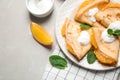 Delicious thin pancakes with oranges and cream on table, flat lay