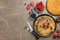 Delicious thin pancakes served with chocolate paste and berries on grey marble table, flat lay. Space for text Royalty Free Stock Photo