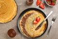 Delicious thin pancakes served with chocolate paste and strawberries on grey marble table, flat lay Royalty Free Stock Photo