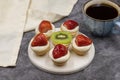 Delicious tiny tartlets tarts, open pastry pies on a dark background. Royalty Free Stock Photo