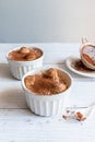 Delicious tiramisu dessert with cocoa and savoyardi cookies in white ceramic jars on a gray background. Vertical photo Royalty Free Stock Photo