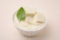 Delicious tofu sauce and basil leaf in bowl on beige background