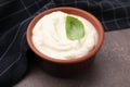 Delicious tofu sauce and basil leaf in bowl on brown table, closeup