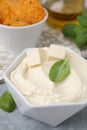 Delicious tofu sauce and basil leaves on grey table, closeup