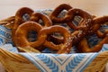 Delicious traditional Bavarian pretzels with brown salty crust on traditional Bavarian cocktail napkin in basket