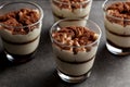 Delicious traditional tiramisu desert served in small glass cups on stone countertop. Royalty Free Stock Photo