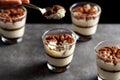 Delicious traditional tiramisu desert served in small glass cups on stone countertop. Royalty Free Stock Photo