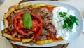 Delicious traditional Turkish Iskender kebab dish with meat, cream, seasoning, bell pepper and french fries as a part of eastern Royalty Free Stock Photo