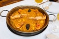 Delicious traditional Valencian seafood paella savory rice dish with shrimps, squid and clams in Paella Pan