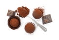 Delicious truffles, cocoa powder and chocolate on white background, top view