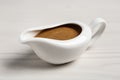 Delicious turkey gravy in sauce boat on white wooden table Royalty Free Stock Photo