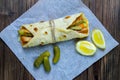 Delicious Turkish doner kebab on pita bread with shaved roasted meat off a traditional vertical rotisserie served with fresh salad