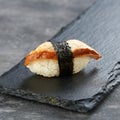 Delicious Unagi Eel Nigiri Sushi on black background. Traditional Japanese cuisine