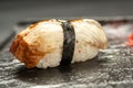 Delicious Unagi Eel Nigiri Sushi on black stone background. Traditional Japanese cuisine