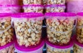 Delicious unbranded sweet and salty popcorn in plastic containers with pink lids Royalty Free Stock Photo