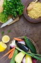 Delicious useful porridge cous cous in a clay plate and raw fresh vegetables in a basket, greens, lemon.