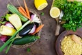 Delicious useful porridge cous cous in a clay plate and raw fresh vegetables in a basket Royalty Free Stock Photo