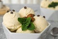 Delicious vanilla ice cream with mint, hazelnuts and chocolate chips in bowl on table Royalty Free Stock Photo