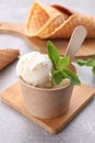 Delicious vanilla ice cream with mint in paper cup on light grey table, closeup Royalty Free Stock Photo