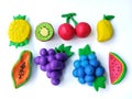 Delicious variety fruits plasticine clay, white background, colorful grapes blueberry shape dough