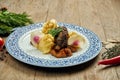 Delicious veal beef cheeks with honey sauce and mashed potato garnish in a blue plate on a wooden background. Close up view Royalty Free Stock Photo