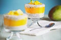 Delicious vegan mango chia pudding with fresh mint springs in a glass jar on a green wooden background