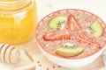 Delicious vegetarian breakfast. Useful porridge from flax seeds with kiwi, strawberries and honey.