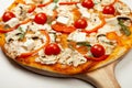 Delicious Vegetarian pizza served on a wooden plate, the ingredients are signature sauce, basil, mozzarella cheese Royalty Free Stock Photo