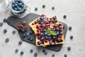 Delicious waffles with blueberries and jam on slate plate Royalty Free Stock Photo