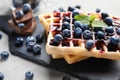 Delicious waffles with blueberries and jam on slate plate, closeup Royalty Free Stock Photo