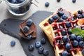 Delicious waffles with blueberries and jam on slate plate, closeup Royalty Free Stock Photo