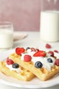 Delicious waffles with fresh berries served on table against pink background Royalty Free Stock Photo