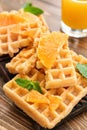 Delicious waffles with orange slices on wooden board Royalty Free Stock Photo