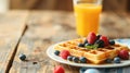 Delicious waffles with syrup and fresh berries, served with orange juice on a rustic table