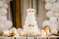 Delicious wedding reception. Cake on a background balloons. Decorated table for wedding. White balloons, candles, autumn leaves Royalty Free Stock Photo