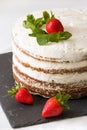 Delicious white cream icing cake with strawberry on the black board. Naked cake with cream, decorated with strawberries and mint. Royalty Free Stock Photo