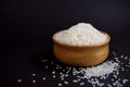 Delicious white rice grains in a stylish wooden bowl, isolated on a black background Royalty Free Stock Photo