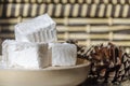 Delicious white traditional bulgarian turkish delight on wooden dish sprinkled with icing sugar like snow. Oriental sweets for tea