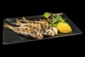 Delicious whole fried Bluefish with lemon on a plate with reflection