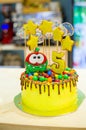 Delicious yellow cake for the birthday of a 5-year-old child, yellow stars and transparent candies on the cake, the number 5