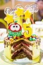 delicious yellow cake cut for the birthday of a 5-year-old child, yellow stars and transparent candies on the cake, the number 5 a