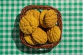 Delicious yellow cookie of corn on basket and green plaid table. Royalty Free Stock Photo