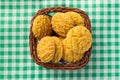 Delicious yellow cookie of corn on basket and green plaid table. Royalty Free Stock Photo