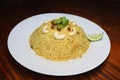 Delicious Yellow rice, plums, cashew nut, mint leaf,lemon slice on white plate on wood table Royalty Free Stock Photo