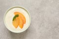 Delicious yogurt with fresh peach and mint on grey table, top view. Space for text Royalty Free Stock Photo