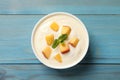 Delicious yogurt with fresh peach and mint on light blue wooden table, top view Royalty Free Stock Photo