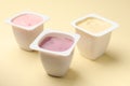 Delicious yogurts in plastic cups on yellow background, closeup Royalty Free Stock Photo
