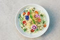 Delicious zucchini spaghetti salad with hempseeds, spinach, pumpkin seeds, decorated with flowers, in bowl, isolated over white Royalty Free Stock Photo